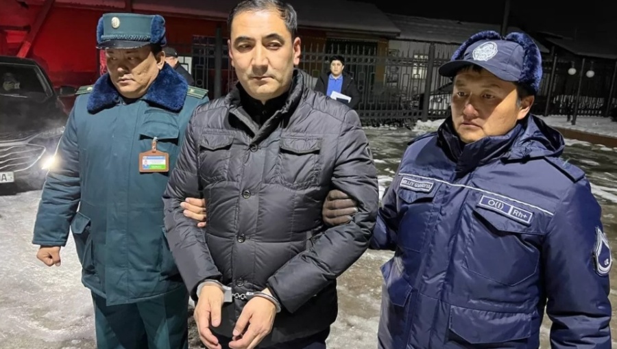 Muzaffar Aliyev being detained by police officers.